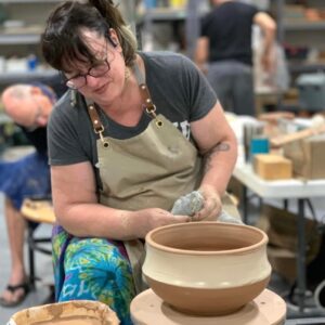Student working on a wheel thrown bowl at The Village Potters workshop
